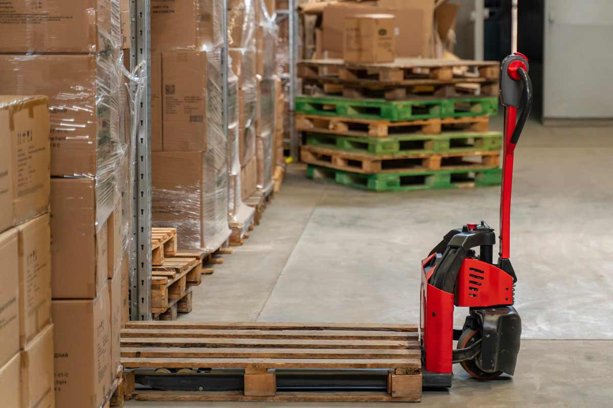 Magatzem amb un carretó amb un palet al damunt.